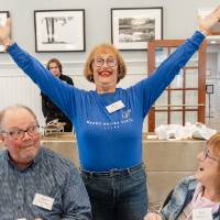 Sheree Rizzardi standing with both arms wide in air with big smile